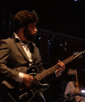 2009년 5월 9일, Believers Never Die Tour Part Deux에서 공연하는 조 트로만. 기업 미국을 비판하는 의미로 정장을 입고 있다.