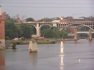 I-35 교량의 붕괴된 거더(녹색)가 보이는 사고 현장. 스톤 아치 브리지에서 바라본 모습이며 뒤로 보이는 다리는 10번가 교량이다.