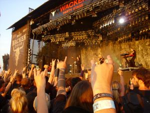 Turunen with her support band in front of a crowd at the Wacken Open Air.