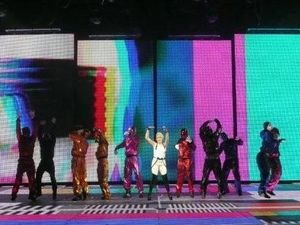 LED 배경 앞에서 댄서들과 함께 공연하는 미노그