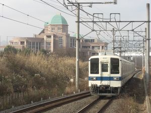 오고세선 8000계 열차가 사카도행 열차로 가와카도역에 접근하며 사이타마 헤이세이 중학교가 배경으로 보이는 모습, 2008년 12월