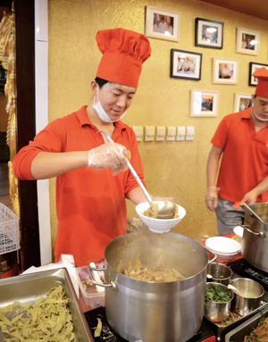 거우부리 물 식당의 요리사가 아침 식사 시간에 궈바차이 요리를 하고 있다.