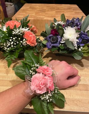 고등학교 꽃꽂이 디자인 학생이 제작한 꽃꽂이 모음. 이 사진은 두 개의 둥근 꽃꽂이와 코르사주를 보여준다.