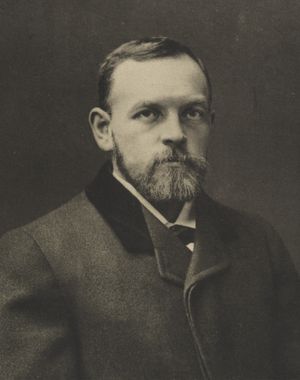 세련된 옷을 입은 중년의 수염이 난 남자의 모습.