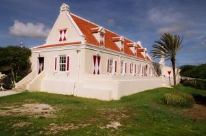 붉은 지붕이 있는 흰색 농장 건물, 주변의 나무