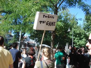 여성이 "You Lose The Game"이라고 적힌 표지판을 들고 있다.