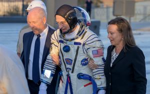 미국 항공우주국(NASA) 부국장 켄 보워삭스 (왼쪽)와 NASA ISS 프로그램 부매니저 다이나 콘텔라(오른쪽)가 페팃을 소유즈 MS-26으로 안내하고 있다. 보워삭스는 또한 원정 6에서 페팃의 사령관이었다.