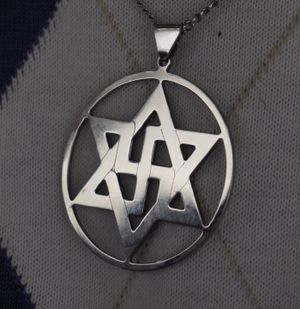 라엘교 상징을 나타내는 메달; 신봉자들은 일반적으로 자신들의 믿음을 나타내기 위해 이 메달을 착용한다.