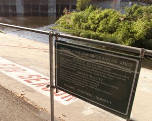 엘리시안 밸리 강 레크리에이션 구역 북쪽 접근 지점의 표지판. 물과의 접촉 시 주의를 요한다는 내용이 적혀 있다.