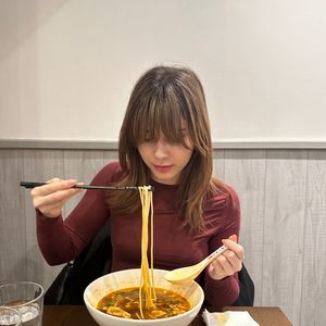 영국 런던에서 뤄쓰펀을 즐기는 여성. 그녀의 뤄쓰펀은 절인 죽순, 절인 녹두, 튀긴 두부 껍질, 땅콩과 함께 제공된다.