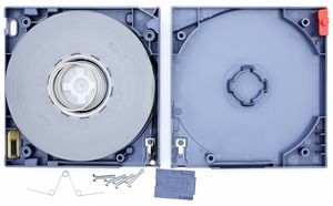 상단 덮개가 제거되어 내부 구성 요소가 보이는 LTO-3 카트리지. 오른쪽 상단: 쓰기 방지 탭. 왼쪽 하단: 카트리지 메모리 칩. 하단: 테이프 접근 게이트