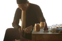 대나무 파이프로 thuốc lào를 피우는 남자