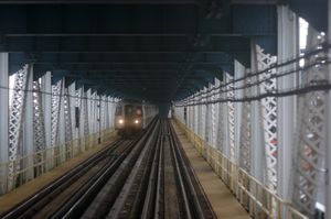 D}} 열차가 북쪽 선로를 이용하여 다리를 건너고 있다.