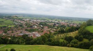 글래스톤베리 토르에서 바라본 글래스톤베리. 붉은 지붕의 집들과 주변의 나무, 밭.