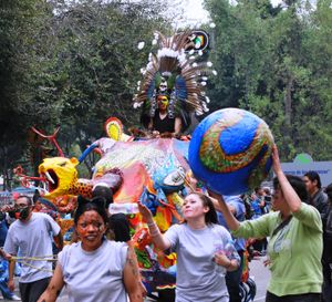 아즈텍 의상을 입은 참가자가 탄 알레브리헤 중 하나를 끌고 가는 참가자들