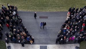 영부인 미셸 오바마와 버락 오바마 대통령이 2011년 투손 총격 사건 희생자들을 위한 묵념을 주도한 후 백악관으로 돌아오고 있다.