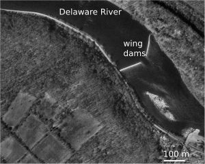 델라웨어 강 럼버빌 댐의 항공 사진. 방사제(윙 댐 또는 그로인) 위로 물이 흐르고 있으며, 사이에는 항해용 수로가 보인다.