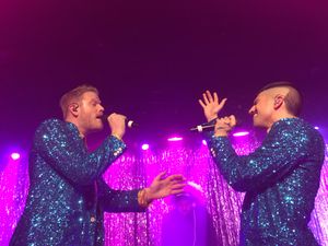 Scott Hoying and /mitch Grassi wearing sparkly suits, facing each other singing onstage.