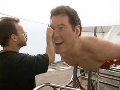 웃는 남자의 거대한 복제품을 작업하는 남자