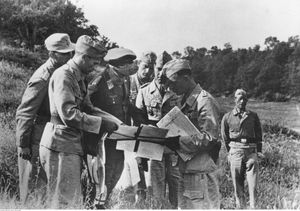 1944년 5월 이탈리아 전선에서 장교들과 지도를 연구하는 독일 공군 원수 볼프람 프라이헤어 폰 리히트호펜. 오른쪽 장교는 아프리카 군단 완장을 착용하고 있다.
