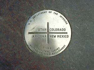 사합점 기념물 중앙에 새겨진 경계 표지. 애리조나주, 유타주, 콜로라도주, 뉴멕시코주 4개 주가 만나는 미국 유일의 주 사합점이다.
