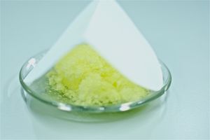 접힌 종이 위에 있는 시계 접시 위의 결정 고체