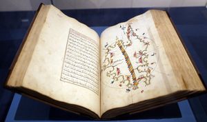 한 페이지에 아랍어 텍스트가 있고 반대편에 다색 그림지도가 있는 대형 책 열람