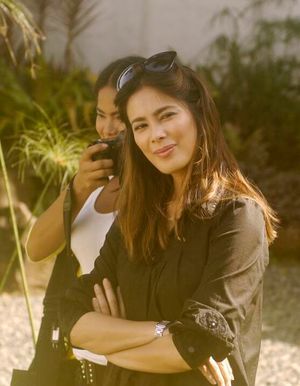 아키노가 팔짱을 끼고 검은색 긴팔 셔츠를 입고 있는 이미지