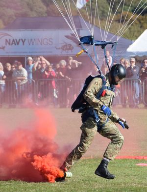 영국 Lightning Bolts Army Parachute Display Team의 낙하산병이 운반하는 붉은 연기