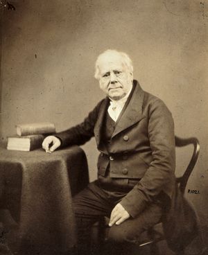 a middle-aged man in Victorian clothes, seated