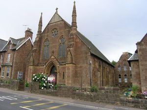 아치형 출입구와 창문이 있는 석조 건물. 두 개의 작은 탑.