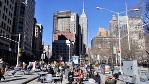 매디슨 스퀘어의 브로드웨이에 있는 보행자 광장; 엠파이어 스테이트 빌딩이 배경에 있고, 브로드웨이는 이 지점에서 단일 차선으로 줄어든다 (오른쪽)