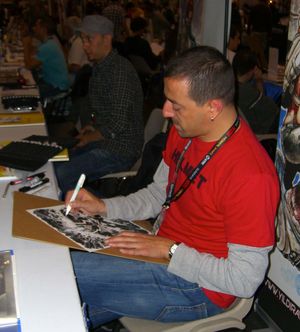 츠나르가 뉴욕 코믹콘에서 스케치하고 있다. 그의 왼쪽에는 동료 터키 만화가 마흐무트 A. 아스라르가 있다.