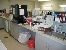 혈액학 (검은색 분석기) 및 요검사 (열린 원심 분리기의 왼쪽)를 위한 검사실 장비