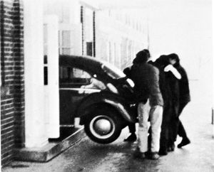 시머 칼리지 학생들이 VW 비틀을 캠퍼스 건물로 밀어넣는 모습