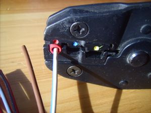 크림핑 공구로 전선과 커넥터를 함께 압착하는 모습