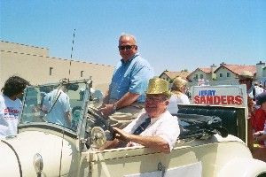 제리 샌더스가 2005년 7월 4일 샌디에이고의 미라 메사 지역에서 교육구 위원회 소속 존 위트와 함께 퍼레이드를 하고 있다.