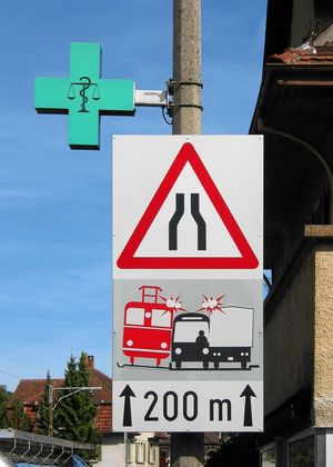 도로와 철도 근접의 위험을 그래픽으로 경고하는 표지판