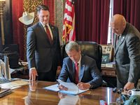 짐 필런 주지사가 네브래스카 주에서 사진 유권자 신분증을 시행하는 입법안 514호에 서명하는 모습. 벤 핸슨과 톰 브루어 상원의원이 지켜보고 있다.