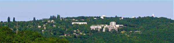 크림 천체물리 관측소와 근처 "스칼리"( "바위")에서 바라본 나우치니의 모습. 수평선 위로 보이는 관측소 돔은 (왼쪽에서 오른쪽으로) 2.6m ZTSH 망원경, 1.25m AZT-11 망원경, BST-1 태양 망원경이다.