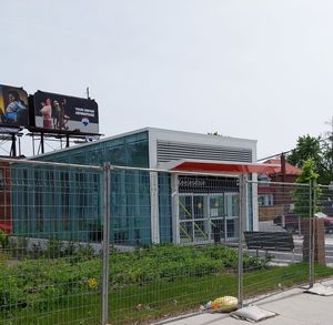 작은 유리 패널 지하철역 입구 사진, 옆에 녹지가 있음.