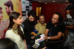 Khan and Sonam Kapoor in front of a bank of microphones and cameras