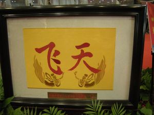 Feitian 우주복의 팔 배지에 있는 "Fei Tian" 텍스트와 여신 이미지