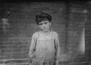 펠 시티 면화 공장에서 일하는 어린 도퍼(doffer) 중 한 명, 1910년. 사진은 루이스 하인(Lewis Hine)이 촬영