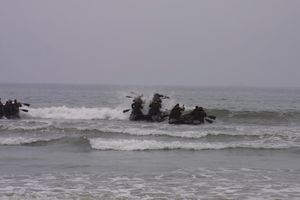 포스리컨 팀 운용병 분대가 전투 고무 정찰정(CRRC)을 타고 해변에서 바다로 나아가는 모습은 기초 정찰 과정에서 습득한 기술이다.
