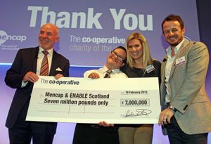 던이 Mencap의 수표를 받는 모습