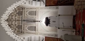 조각된 스투코로 장식된 미흐라브. 상단에는 무카르나스 돔의 일부가 보인다.