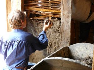실험 고고학으로 바이킹의 건축 방식으로 뼈대(Wattle)에 흙을 바르는 모습