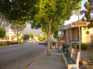 AC Transit BRT 정류장과 리치먼드 동부의 상점들이 있는 맥도날드 애비뉴의 나무가 늘어선 샌 파블로 애비뉴