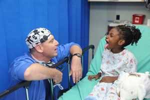 수술 예정인 어린이의 입을 크게 벌려 마취과 의사가 기도 평가를 하고 있다.